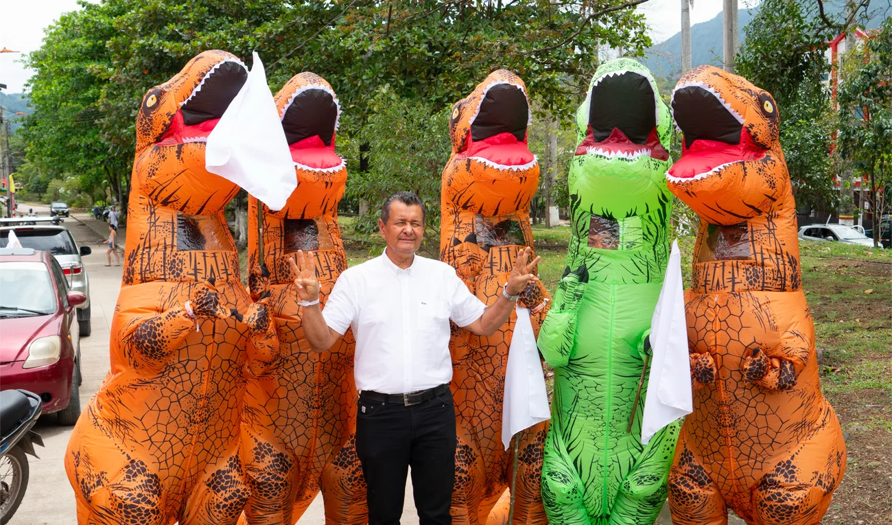 Dinosaurios inflables marchan con la multitud vestida de blanco en Villeta