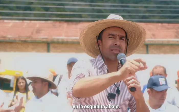 Jorge Rey con sombrero habla en tarima: en la esquinita abajo